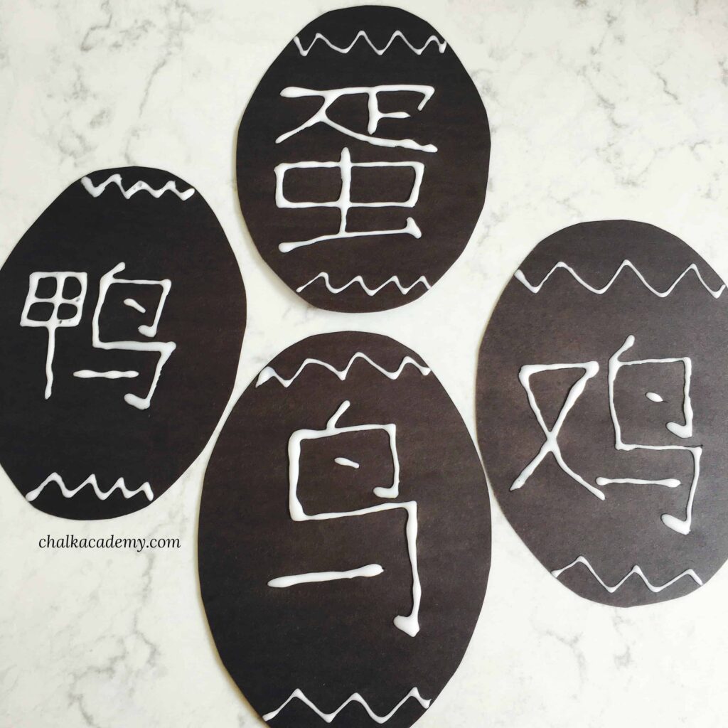 Chinese characters on black paper written with Elmer's glue