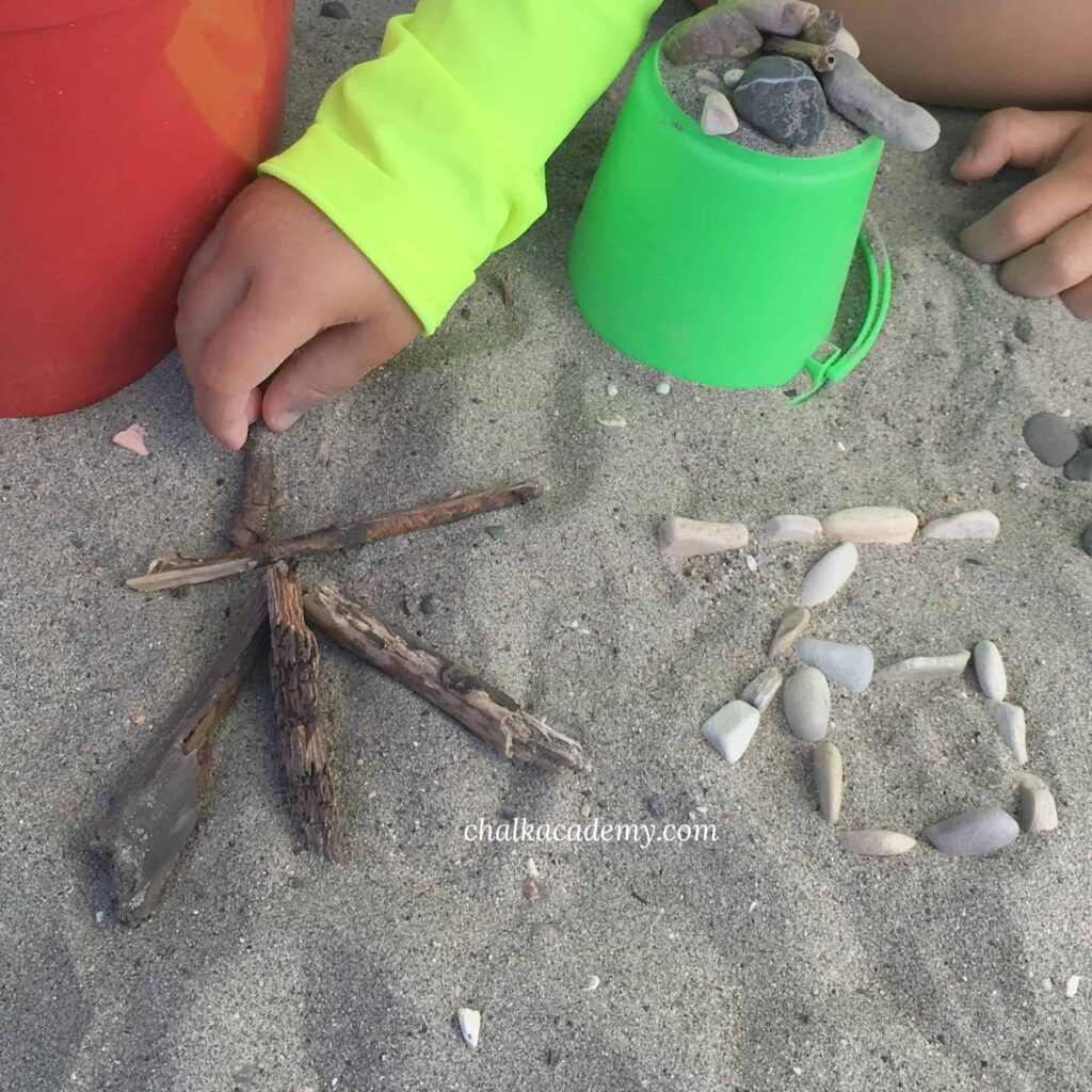Teach Chinese characters at the beach - writing with wood and stones