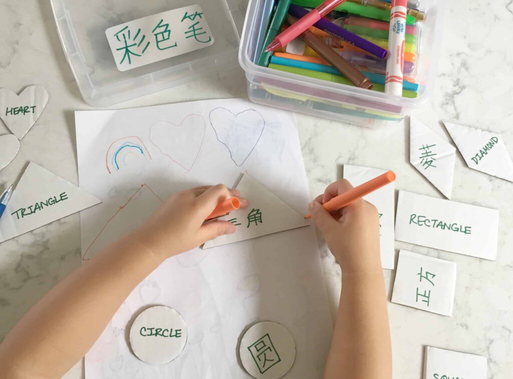 Child using bilingual cardboard triangle shape template