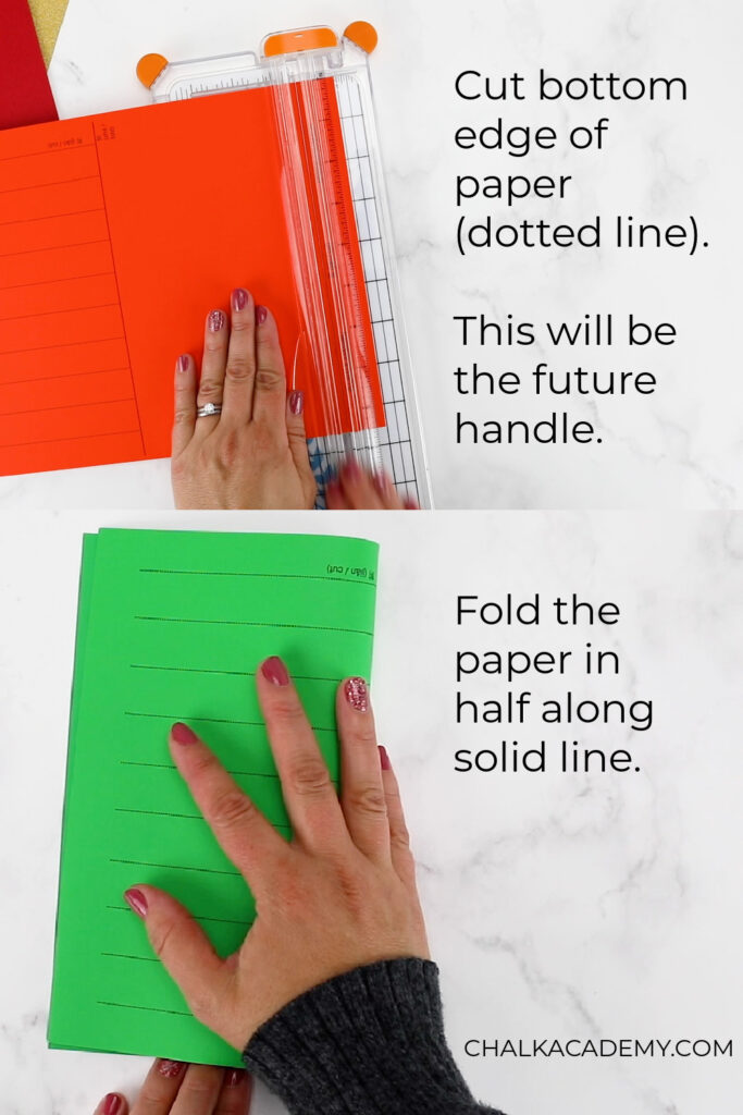 Making a DIY paper lantern out of construction paper: Cut off bottom edge of paper along dotted line. Then fold paper in half along solid line.