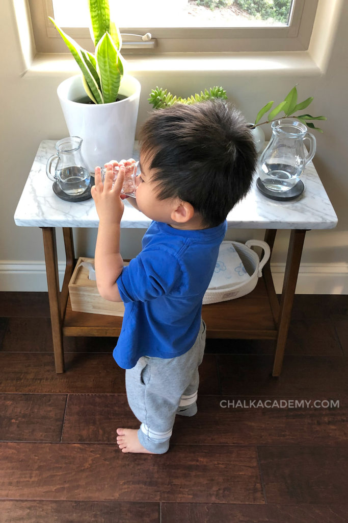 2-year-old drinking from glass shot cup - Montessori inspired water station