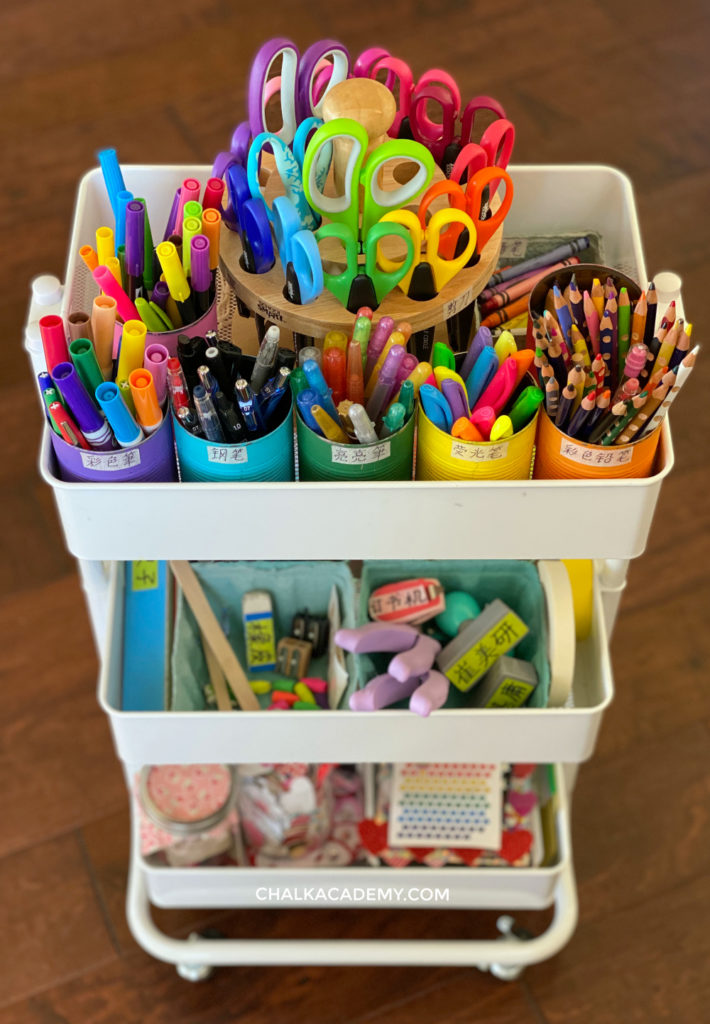 Top of kids art cart with scissor caddy and cans holding art supplies