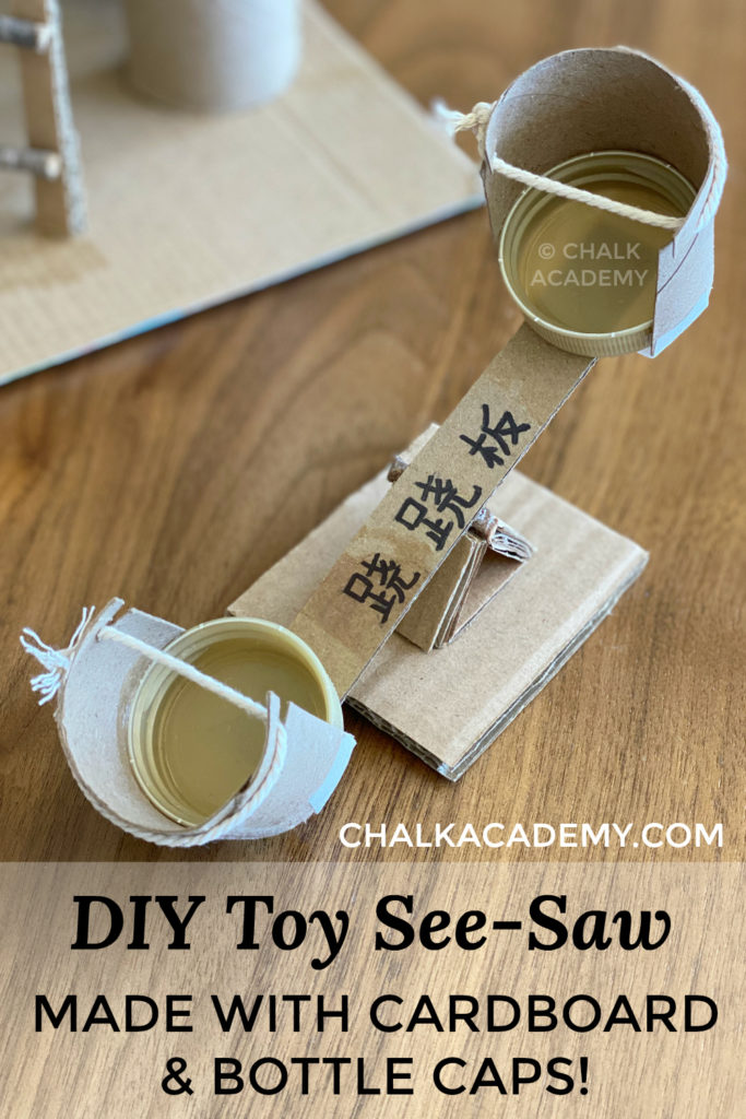 DIY Toy see-saw made with cardboard, toilet paper rolls, and bottle caps