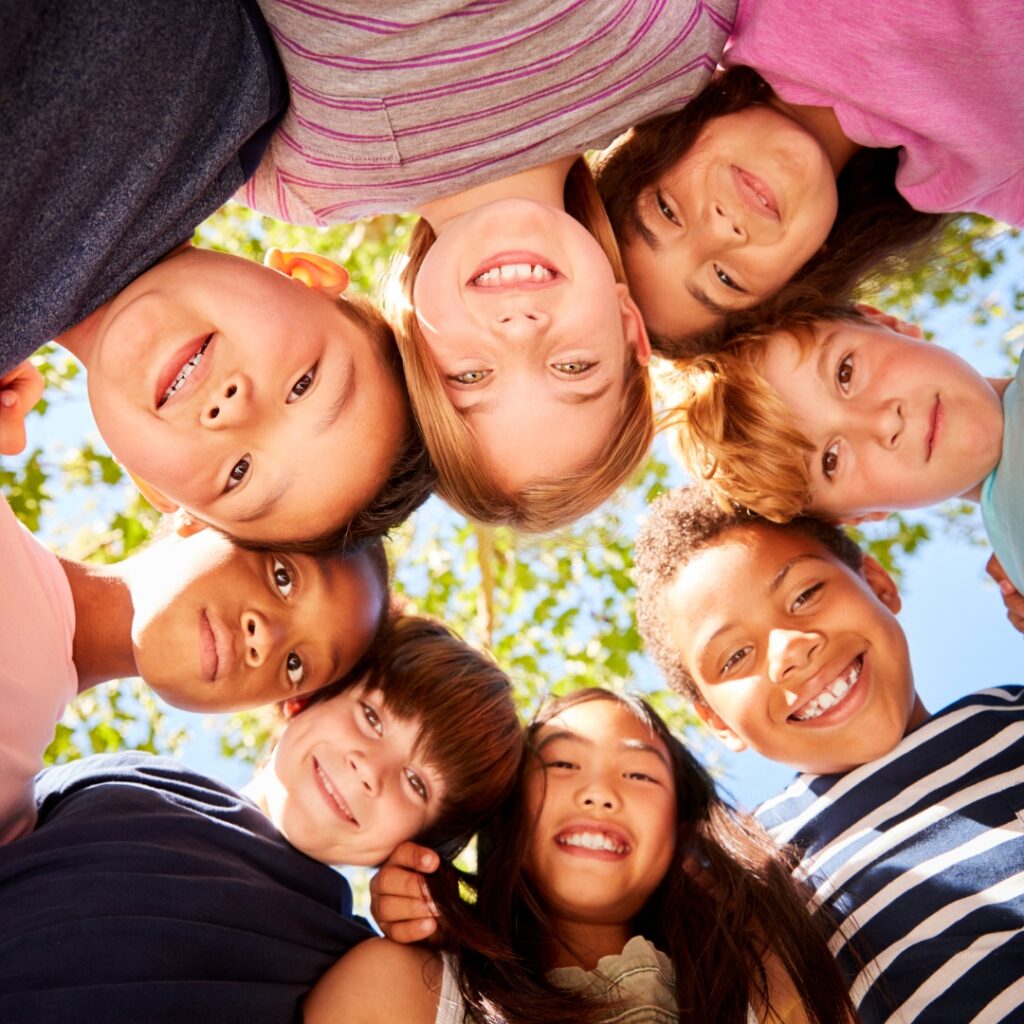 Diverse kids of various races playing and smiling happy together; How to Talk to Kids About Racism Today | Inclusive, Bilingual Resources